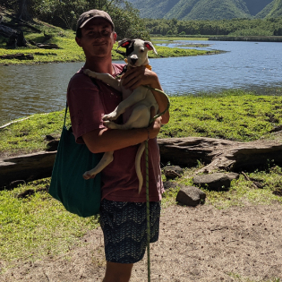 a man and a woman standing in front of a body of water