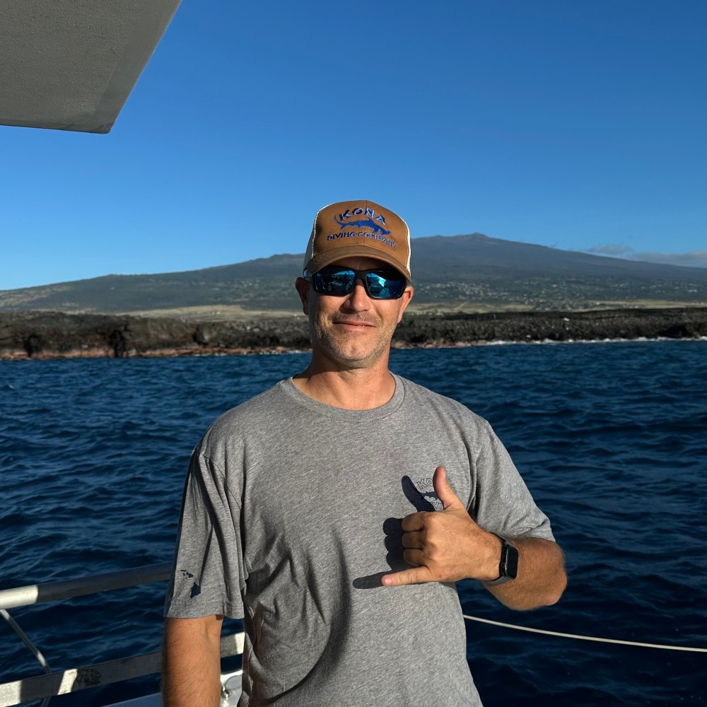 a man standing next to a body of water