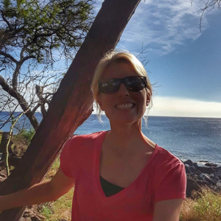 a woman standing next to a body of water