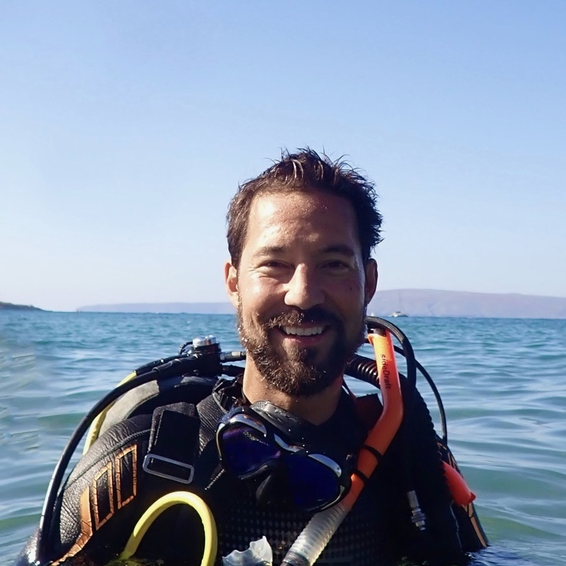 a man standing next to a body of water